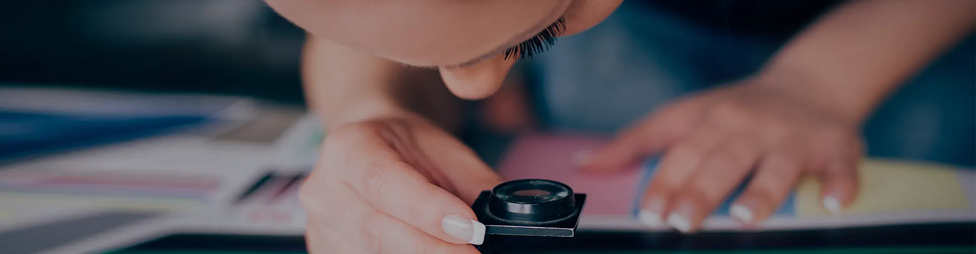 Woman using loupe to examine print job