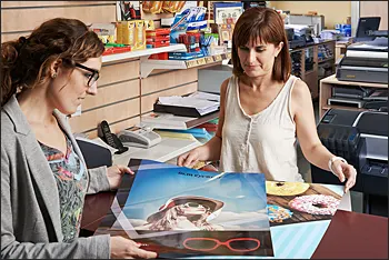 Photo of woman examining printing job in print shop